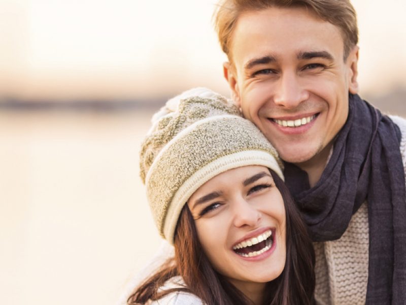 Loving young couple walk on the beach in autumn